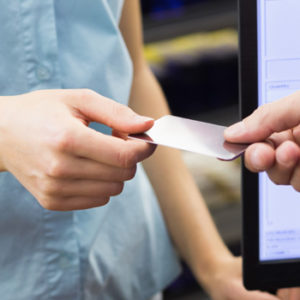 woman handing debit card to cashier